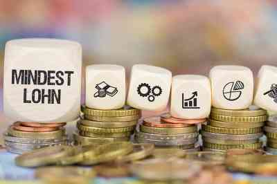 Münzen und Würfel mit Symbolen und Beschriftung Mindestlohn