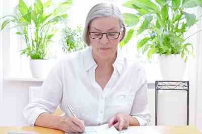 Ältere Dame bearbeitet Unterlagen