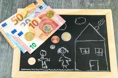 Tafel mit Kinderzeichnung darauf und Bargeld